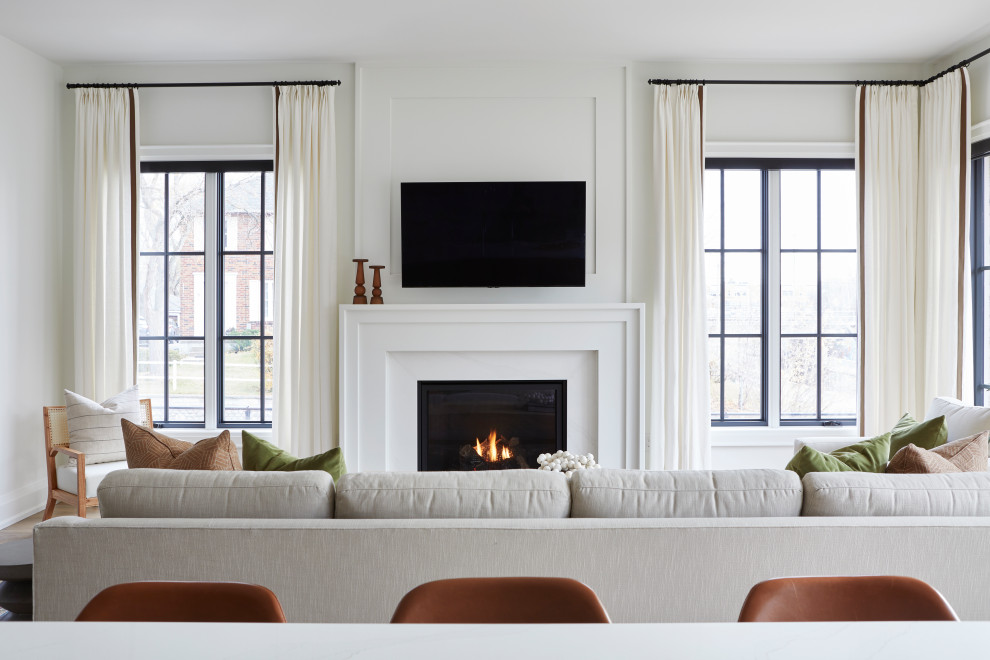 トロントにある高級な広いトランジショナルスタイルのおしゃれなオープンリビング (白い壁、標準型暖炉、漆喰の暖炉まわり、壁掛け型テレビ) の写真