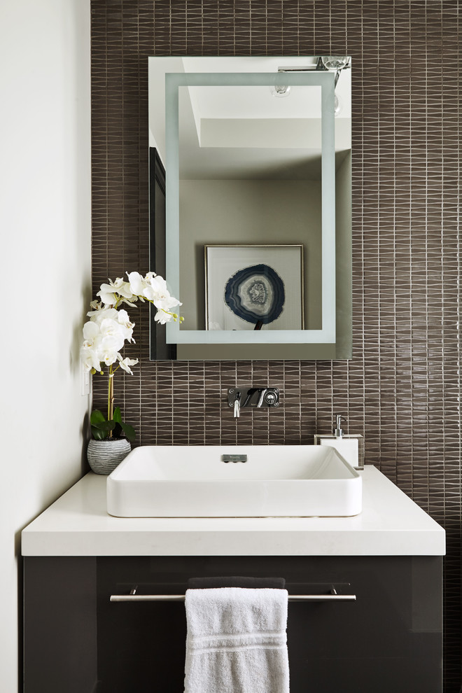 Photo of a transitional powder room in Toronto with flat-panel cabinets, grey cabinets, gray tile, mosaic tile, white walls, a vessel sink, quartzite benchtops and white benchtops.