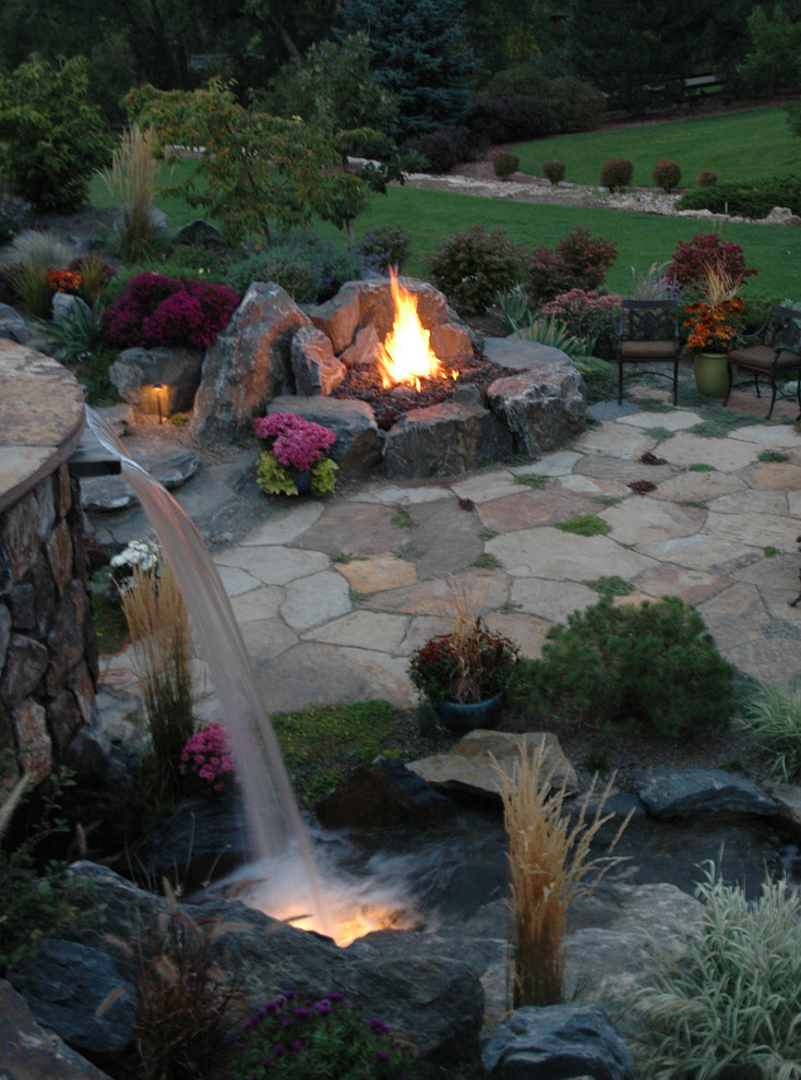 Photo of a mid-sized country backyard full sun formal garden in Denver with a water feature and natural stone pavers.