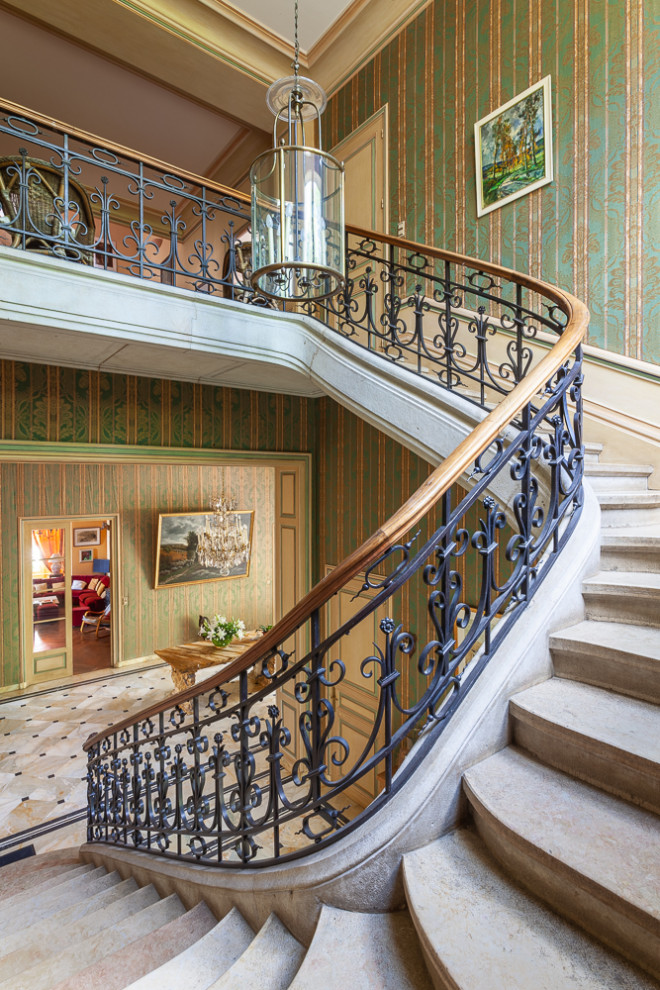 Идея дизайна: большая п-образная лестница в классическом стиле с ступенями из известняка и металлическими перилами