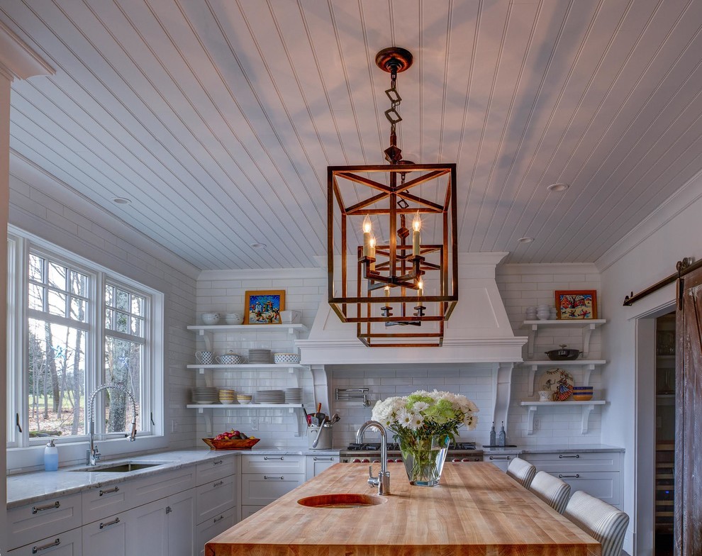 Eat-in kitchen - large transitional l-shaped dark wood floor and brown floor eat-in kitchen idea with an undermount sink, recessed-panel cabinets, white cabinets, wood countertops, white backsplash, subway tile backsplash, stainless steel appliances and an island