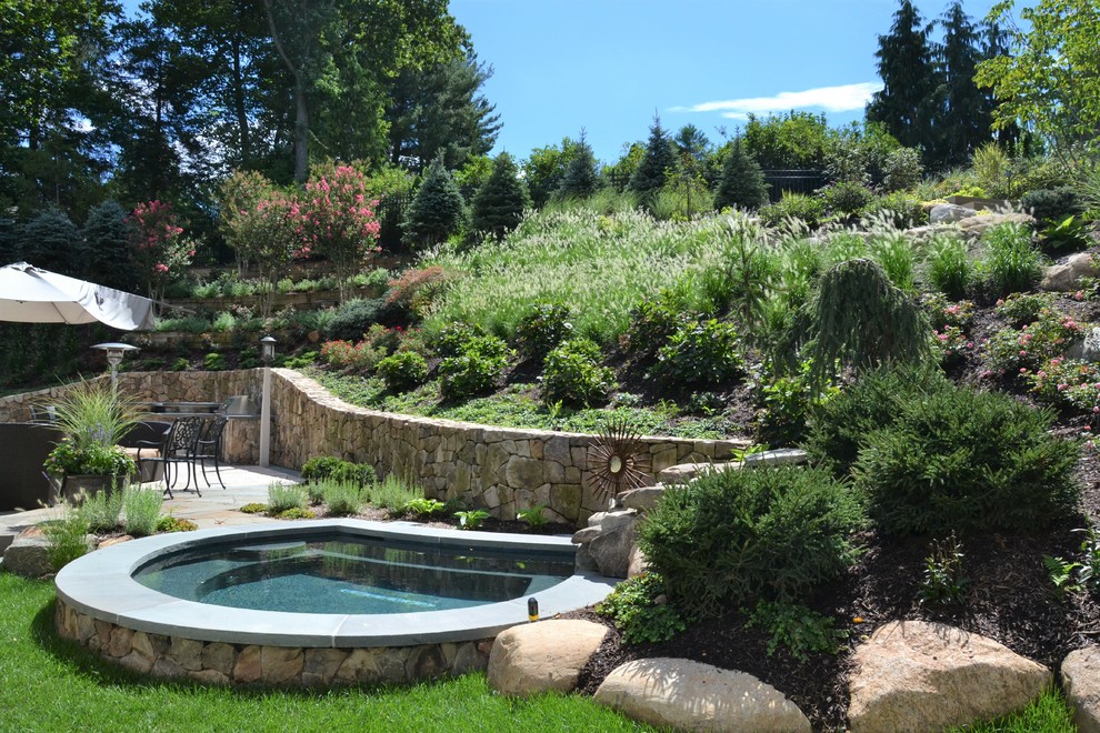 Small contemporary backyard custom-shaped pool in New York with a hot tub and natural stone pavers.