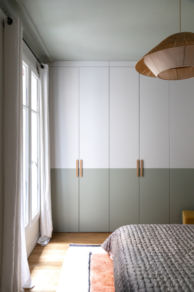 Cette image montre une chambre haussmannienne design de taille moyenne avec un mur vert, parquet clair et aucune cheminée.
