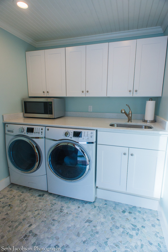 Inspiration for a mid-sized beach style single-wall utility room in Providence with an undermount sink, shaker cabinets, white cabinets, quartz benchtops, blue walls, ceramic floors and a side-by-side washer and dryer.