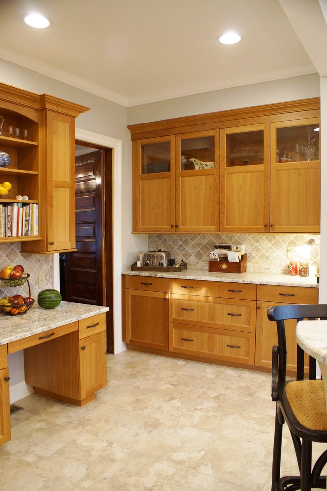 This is an example of a mid-sized traditional l-shaped eat-in kitchen in Other with an undermount sink, recessed-panel cabinets, medium wood cabinets, granite benchtops, brown splashback, stone tile splashback, stainless steel appliances, travertine floors and with island.