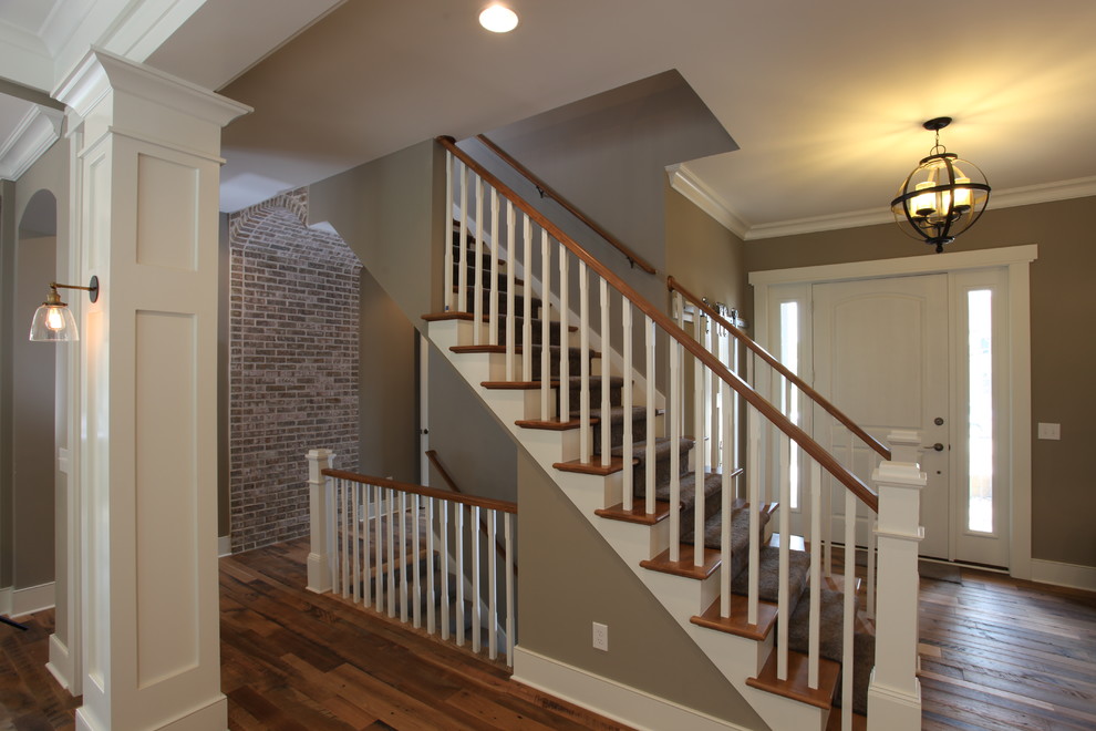 This is an example of a traditional foyer in Columbus with grey walls, a single front door, a white front door and brick walls.