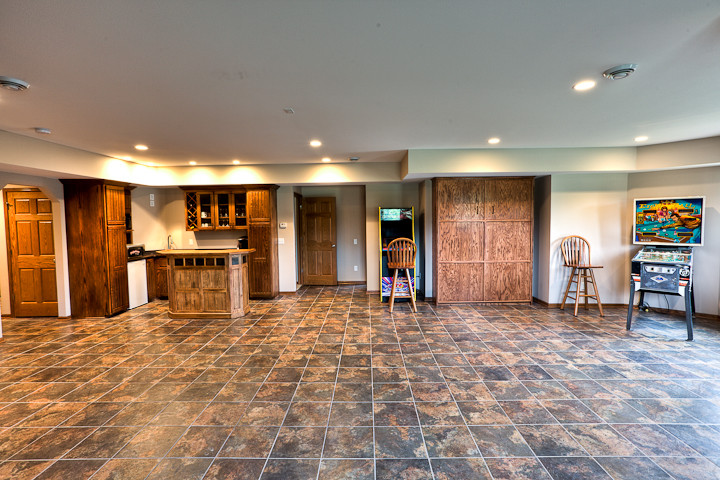 Large traditional basement in Other with beige walls and ceramic floors.