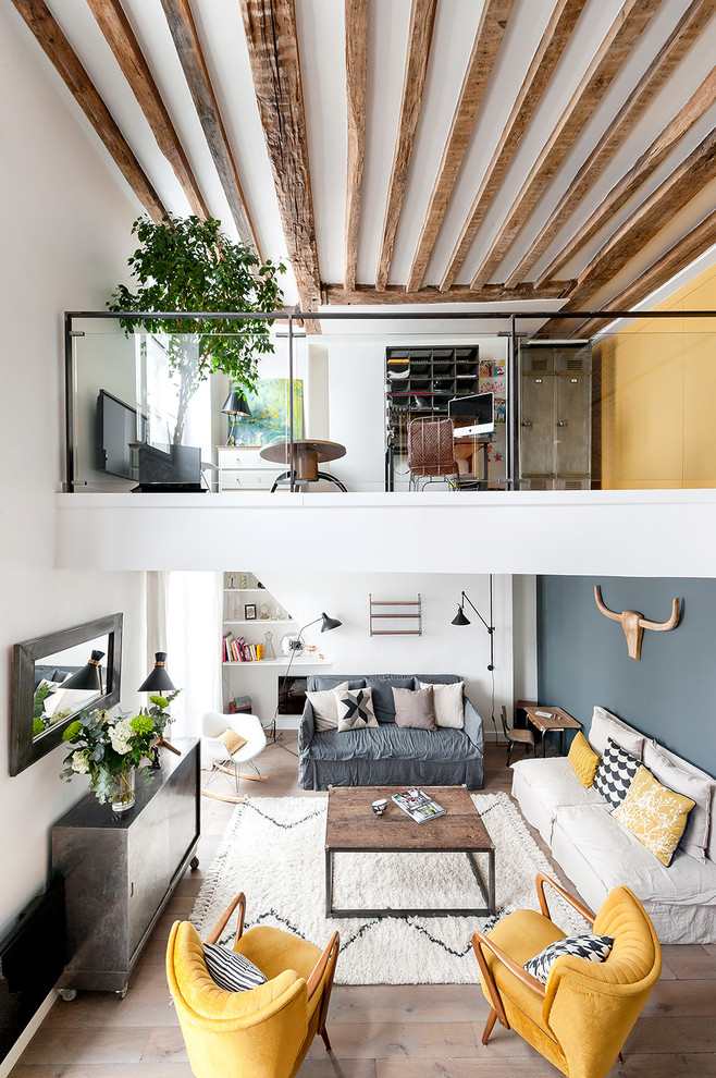 This is an example of a mid-sized industrial loft-style family room in Paris with multi-coloured walls and light hardwood floors.