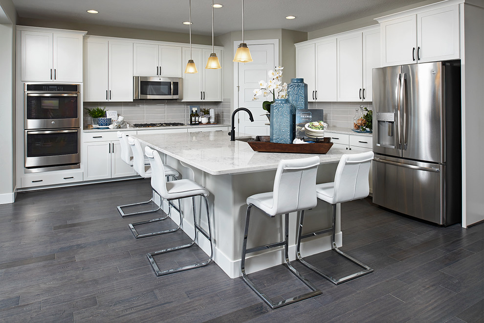 Photo of a contemporary kitchen in Denver with white cabinets, stainless steel appliances, with island and grey benchtop.