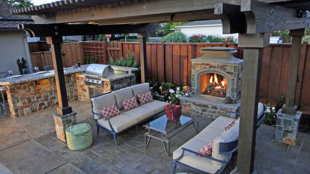 This is an example of a mid-sized country backyard patio in San Francisco with a fire feature, stamped concrete and a pergola.