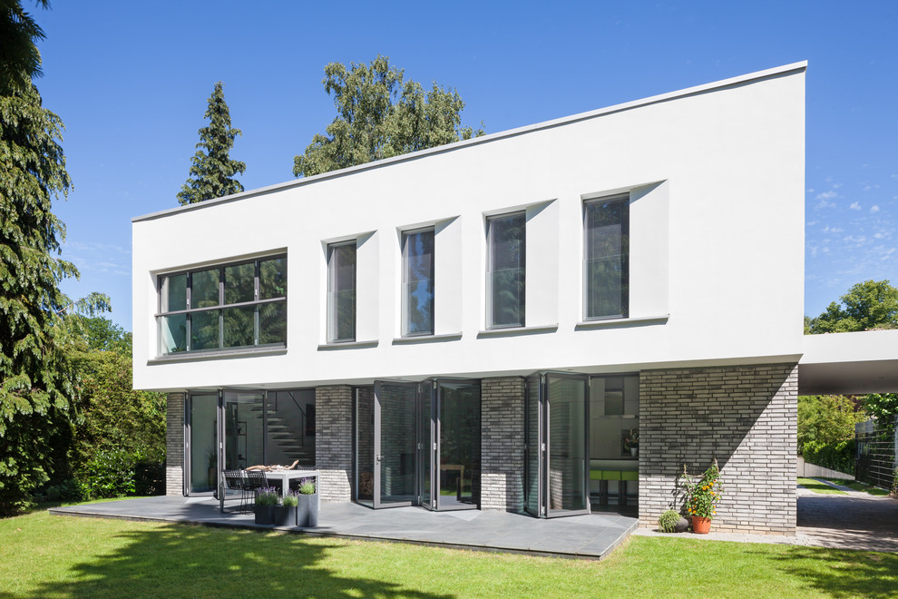 Expansive contemporary two-storey brick white house exterior in Hamburg with a flat roof.