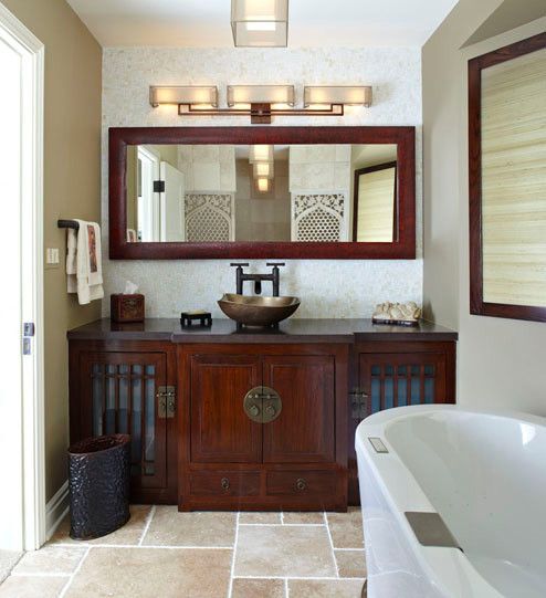 This is an example of a mid-sized asian master bathroom in Chicago with a vessel sink, furniture-like cabinets, medium wood cabinets, concrete benchtops, a freestanding tub, a two-piece toilet, white tile, mosaic tile, beige walls and limestone floors.