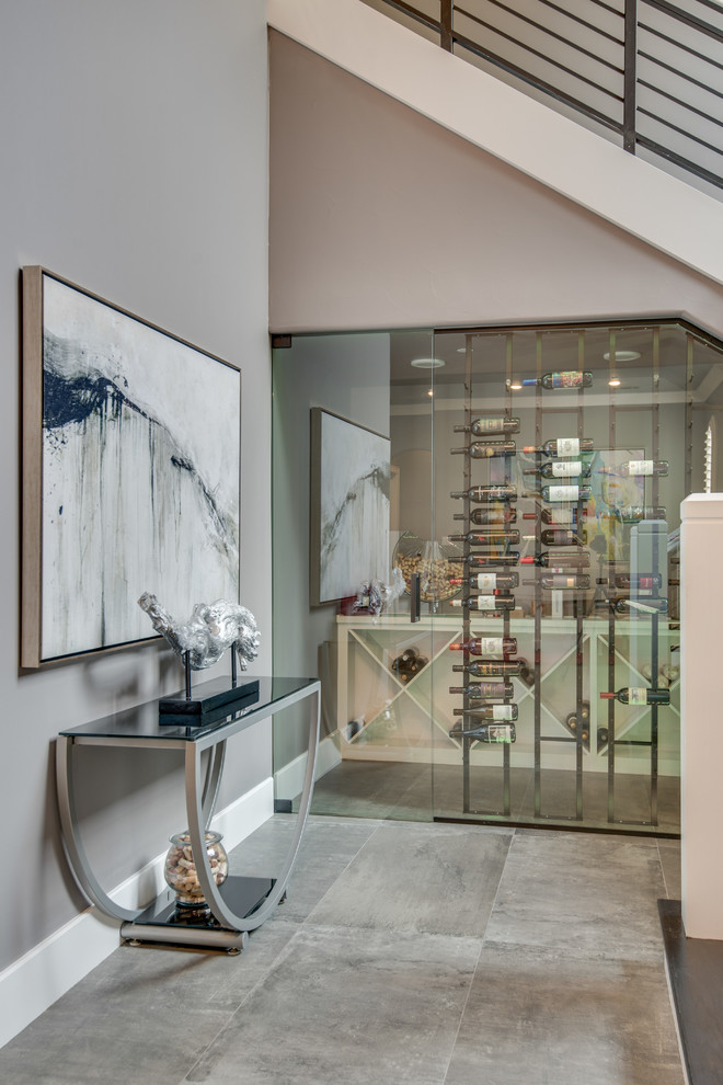 Photo of a transitional wine cellar in Dallas with concrete floors, diamond bins and grey floor.