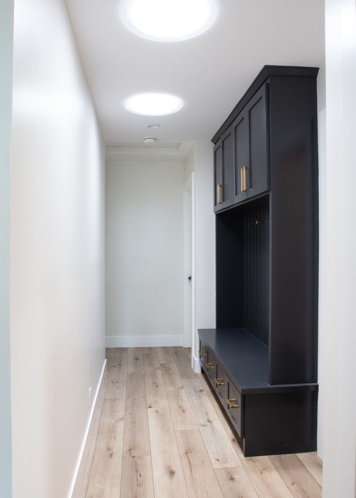 Example of a mid-sized minimalist entryway design in Orange County with white walls