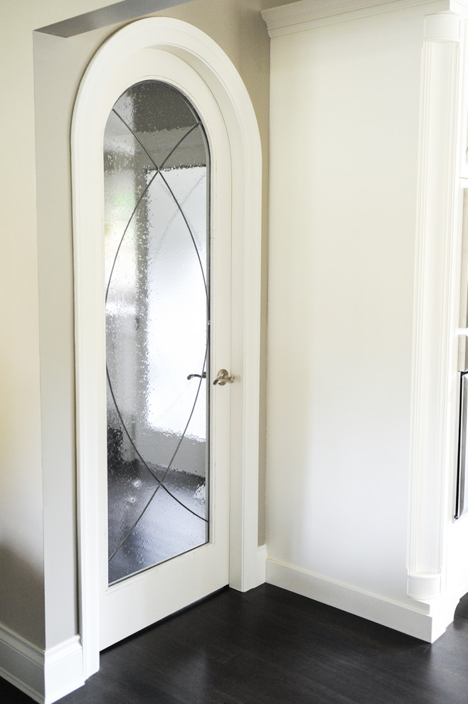 Example of a large transitional u-shaped dark wood floor home design design in Vancouver with a farmhouse sink, recessed-panel cabinets, white cabinets, glass countertops, white backsplash, stainless steel appliances and no island