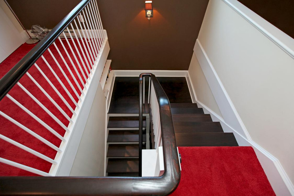 ニューアークにある高級な中くらいなトランジショナルスタイルのおしゃれな折り返し階段 (木材の手すり、フローリングの蹴込み板) の写真