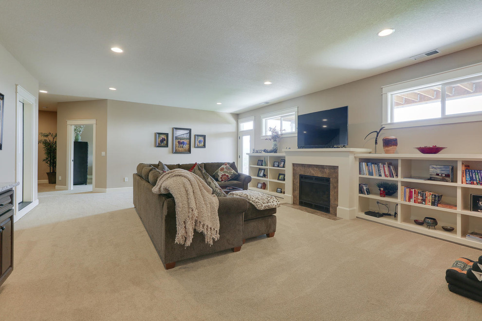 Photo of a large arts and crafts walk-out basement in Portland with beige walls, carpet, a standard fireplace and a tile fireplace surround.
