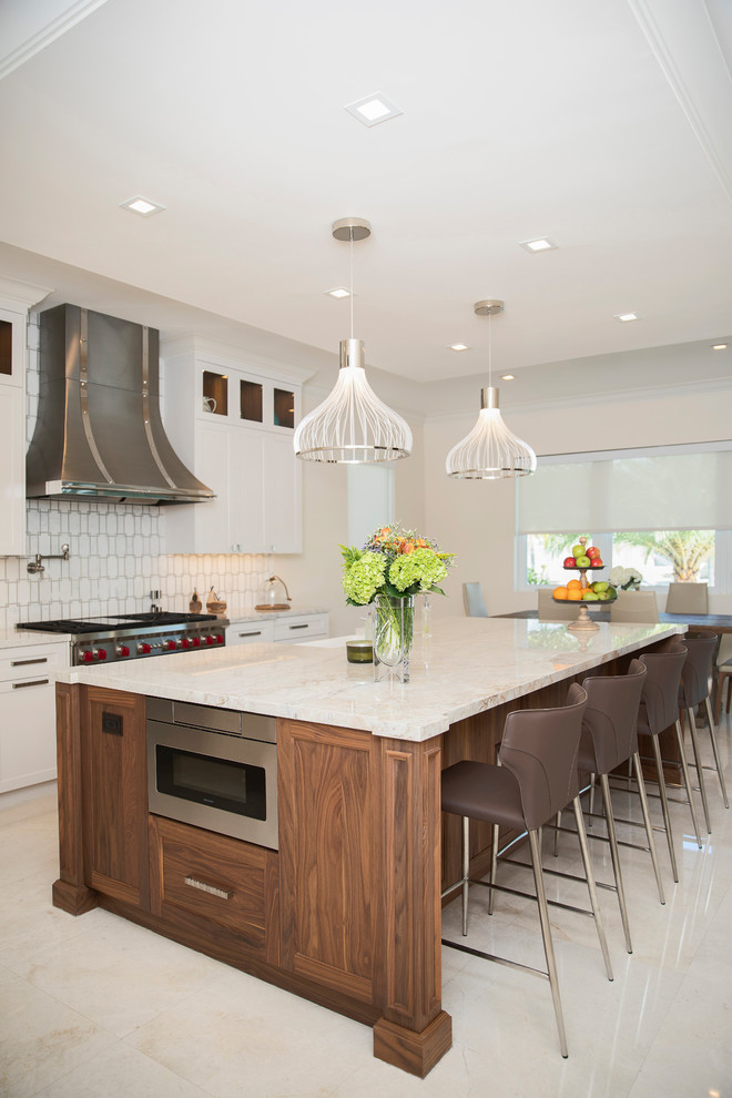 Design ideas for a transitional kitchen in Miami with shaker cabinets, white cabinets, multi-coloured splashback, stainless steel appliances, with island and beige floor.