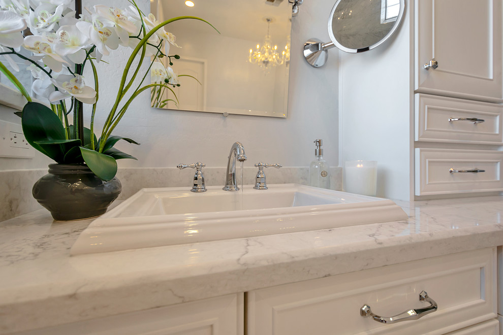 Inspiration for a large transitional master gray tile and marble tile porcelain tile and gray floor freestanding bathtub remodel in Phoenix with recessed-panel cabinets, white cabinets, gray walls, a drop-in sink, quartz countertops and white countertops