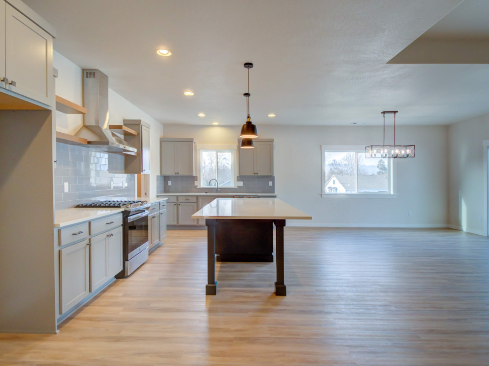 Eat-in kitchen - large transitional l-shaped laminate floor and beige floor eat-in kitchen idea with an undermount sink, shaker cabinets, gray cabinets, quartz countertops, gray backsplash, ceramic backsplash, stainless steel appliances, an island and white countertops