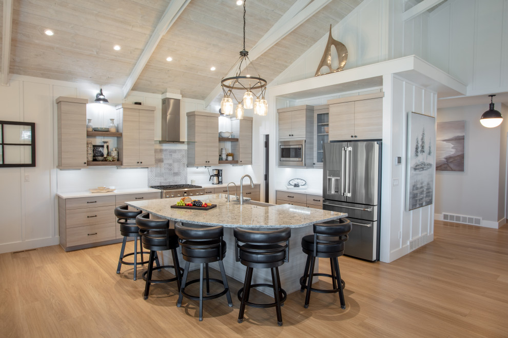 Design ideas for a mid-sized beach style l-shaped open plan kitchen in Other with flat-panel cabinets, light wood cabinets, quartz benchtops, white splashback, stainless steel appliances, with island and vaulted.