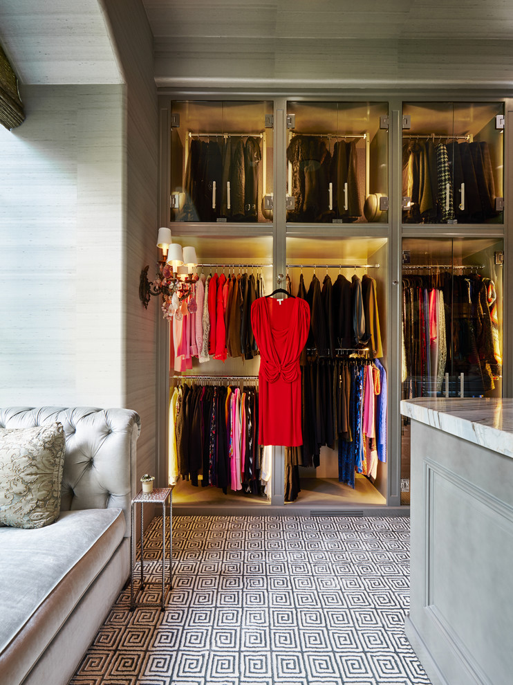 This is an example of a large traditional women's walk-in wardrobe in Dallas with grey cabinets, carpet and glass-front cabinets.