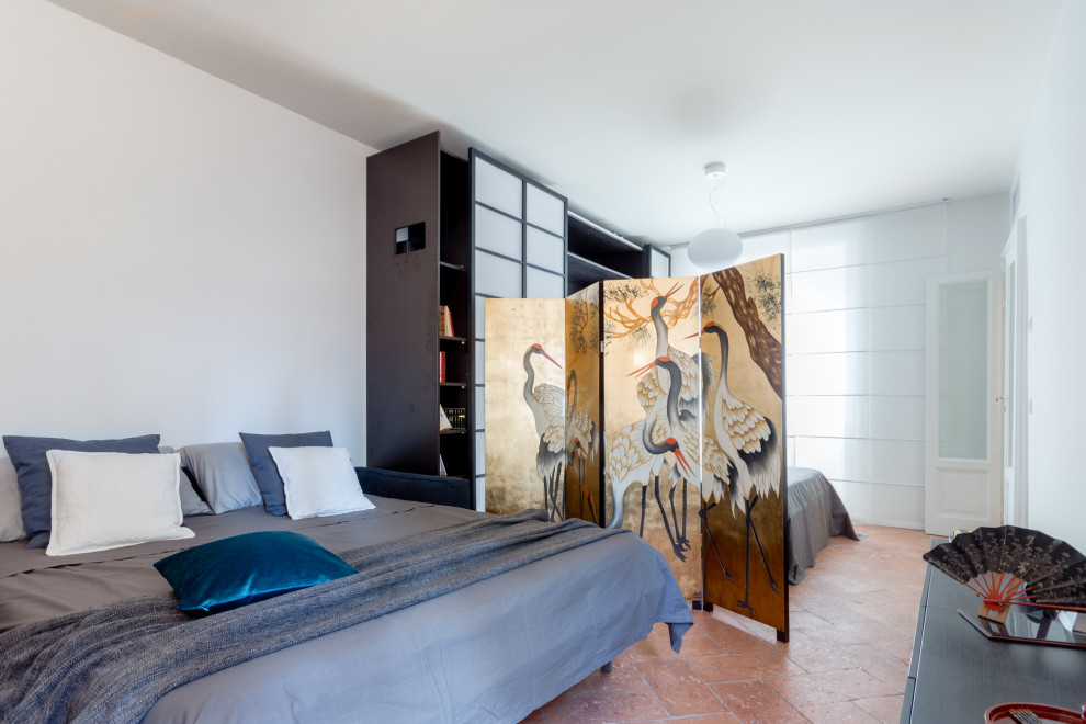 На фото: спальня среднего размера на антресоли в стиле фьюжн с белыми стенами, полом из терракотовой плитки, коричневым полом и многоуровневым потолком с