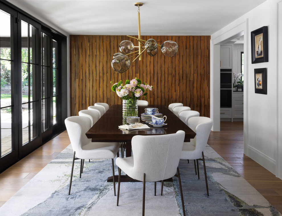 Transitional medium tone wood floor, brown floor and wood wall enclosed dining room photo in Denver with white walls