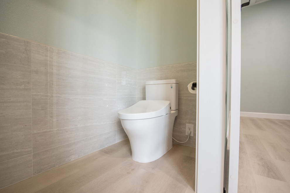 Ispirazione per un bagno di servizio contemporaneo di medie dimensioni con WC a due pezzi, piastrelle in gres porcellanato, pavimento in vinile e mobile bagno freestanding