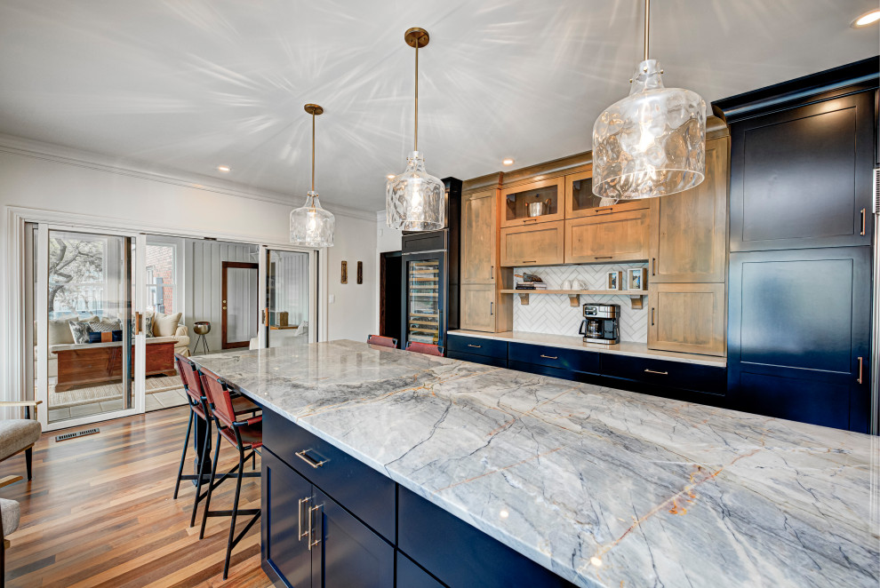Mid-sized contemporary u-shaped separate kitchen in Indianapolis with an undermount sink, shaker cabinets, medium wood cabinets, white splashback, subway tile splashback, stainless steel appliances, medium hardwood floors, with island, marble benchtops, beige floor and white benchtop.
