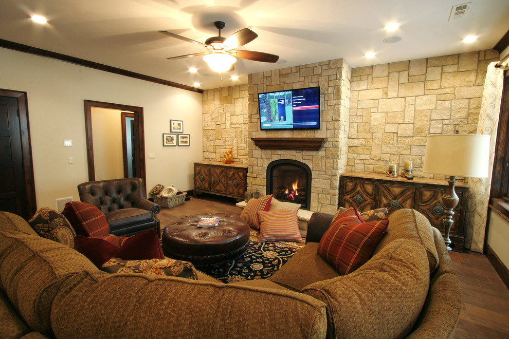Photo of a country walk-out basement in Kansas City with beige walls, ceramic floors, a standard fireplace and a stone fireplace surround.