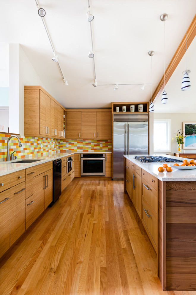Design ideas for a large midcentury l-shaped eat-in kitchen in Seattle with an undermount sink, flat-panel cabinets, medium wood cabinets, quartzite benchtops, multi-coloured splashback, subway tile splashback, stainless steel appliances, with island, white benchtop, medium hardwood floors and brown floor.