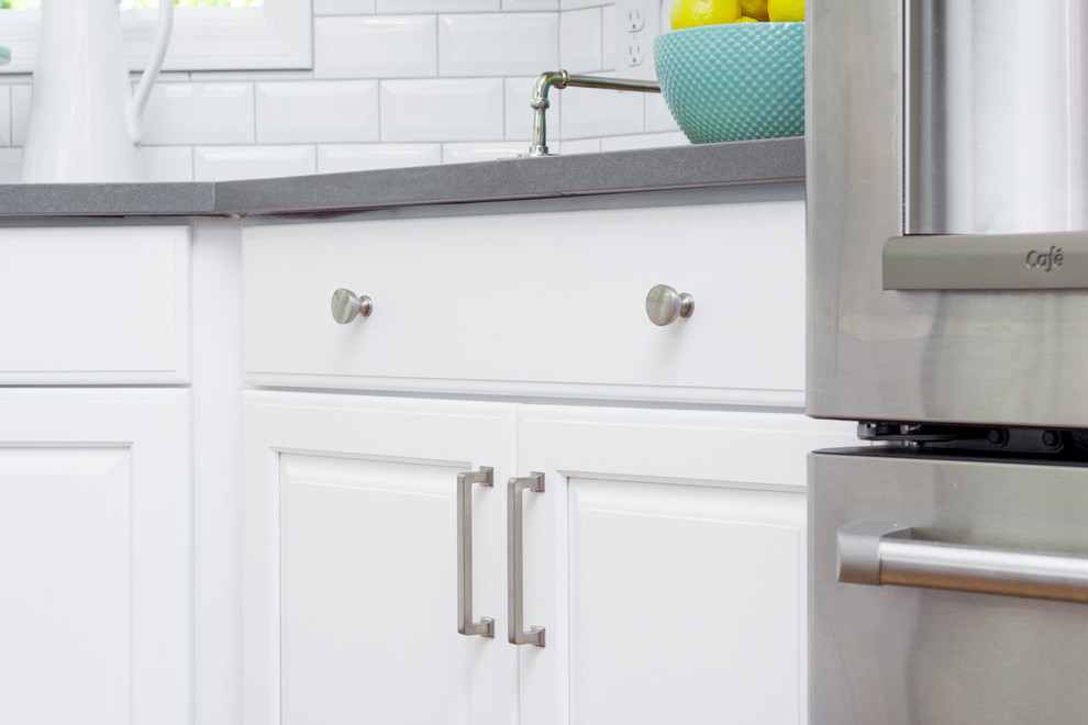 Large transitional u-shaped medium tone wood floor and brown floor eat-in kitchen photo in Detroit with an undermount sink, raised-panel cabinets, white cabinets, quartz countertops, white backsplash, ceramic backsplash, an island and white appliances