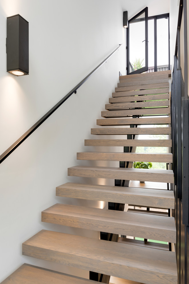 Design ideas for a modern wood floating staircase in Minneapolis with open risers and metal railing.
