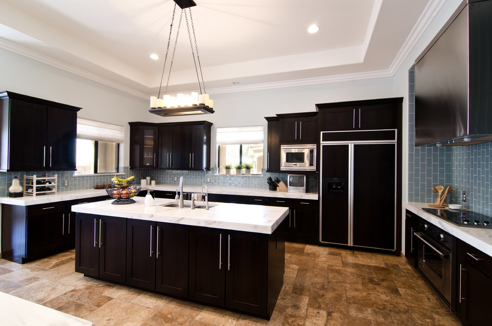 Design ideas for a large transitional u-shaped eat-in kitchen in Phoenix with an undermount sink, shaker cabinets, dark wood cabinets, marble benchtops, blue splashback, glass tile splashback, panelled appliances, travertine floors and with island.