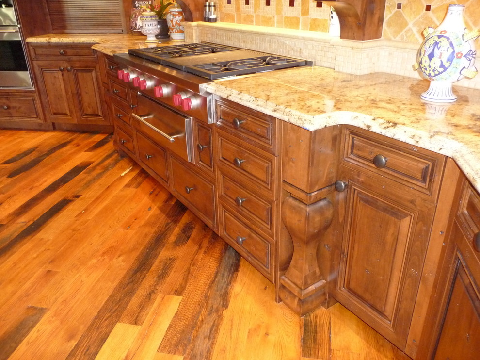 Huge mountain style u-shaped medium tone wood floor kitchen photo in Phoenix with raised-panel cabinets, medium tone wood cabinets, granite countertops, multicolored backsplash, stone tile backsplash, stainless steel appliances and an island