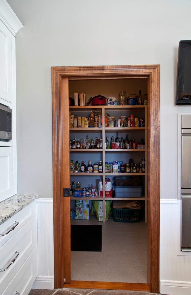 Inspiration for a large transitional u-shaped slate floor and brown floor kitchen pantry remodel with a farmhouse sink, shaker cabinets, white cabinets, granite countertops, yellow backsplash, subway tile backsplash, stainless steel appliances and two islands