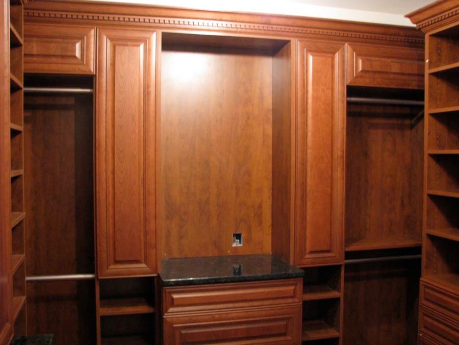 This is an example of a large transitional gender-neutral walk-in wardrobe in New York with medium wood cabinets.