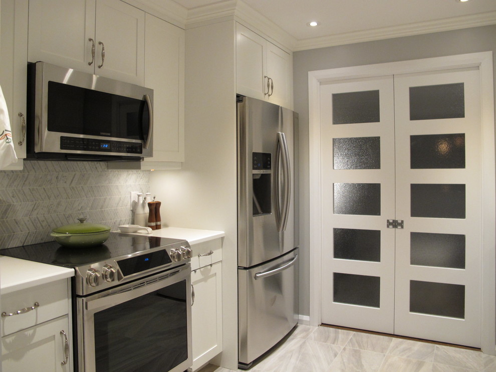 This is an example of a small contemporary galley separate kitchen in Montreal with an undermount sink, shaker cabinets, white cabinets, quartzite benchtops, white splashback, stone tile splashback, stainless steel appliances, porcelain floors and grey floor.