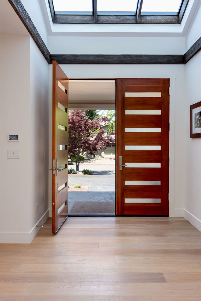 Inspiration for an expansive midcentury front door in Portland with white walls, light hardwood floors, a double front door, a medium wood front door and brown floor.