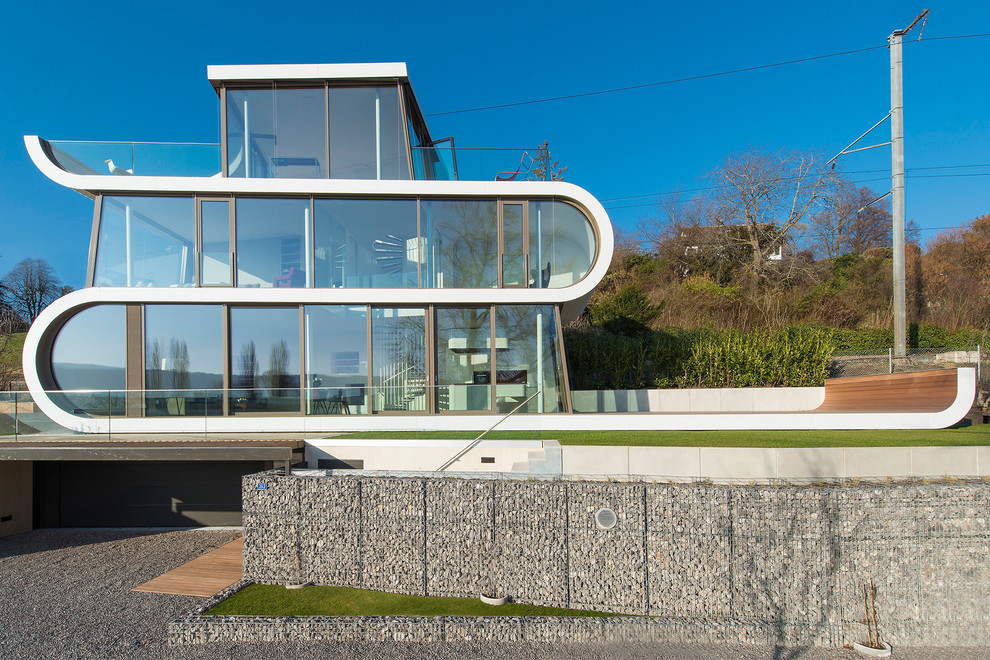 This is an example of a contemporary three-storey glass exterior in Other.