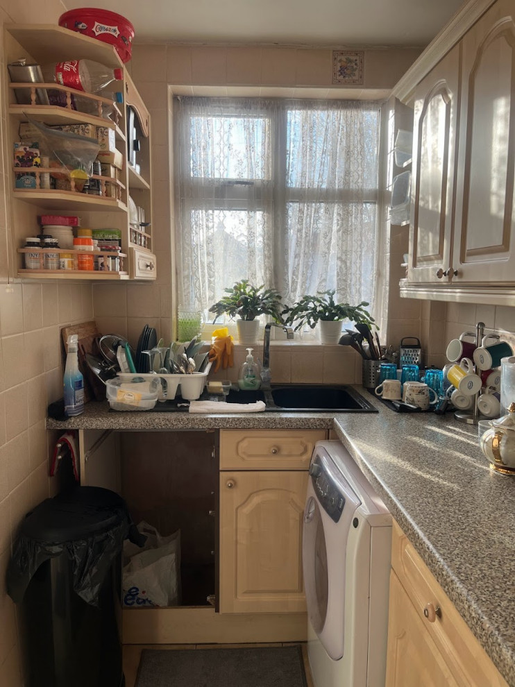 Lantlig inredning av ett litet flerfärgad flerfärgat kök och matrum, med en dubbel diskho, luckor med upphöjd panel, gula skåp, gult stänkskydd, stänkskydd i keramik, vita vitvaror, klinkergolv i keramik, en köksö och gult golv