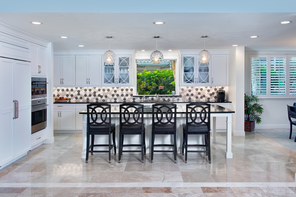 Photo of a large transitional single-wall open plan kitchen in Miami with an undermount sink, recessed-panel cabinets, white cabinets, quartz benchtops, multi-coloured splashback, stainless steel appliances, marble floors, with island, beige floor and brown benchtop.