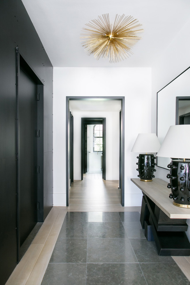 This is an example of a large transitional hallway in New York with white walls, light hardwood floors and beige floor.