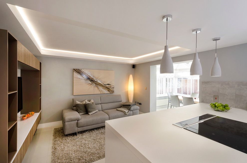 This is an example of a large modern l-shaped kitchen in Devon with a double-bowl sink, flat-panel cabinets, laminate countertops, grey splashback, porcelain splashback, stainless steel appliances, porcelain flooring and a breakfast bar.