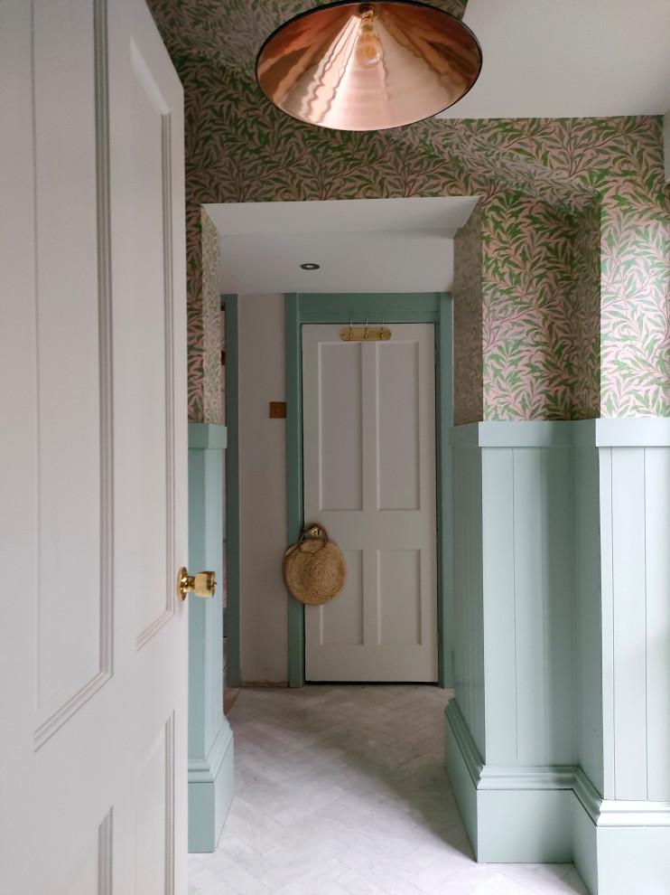 Cette image montre un couloir craftsman de taille moyenne avec un mur blanc, un sol en marbre et du papier peint.