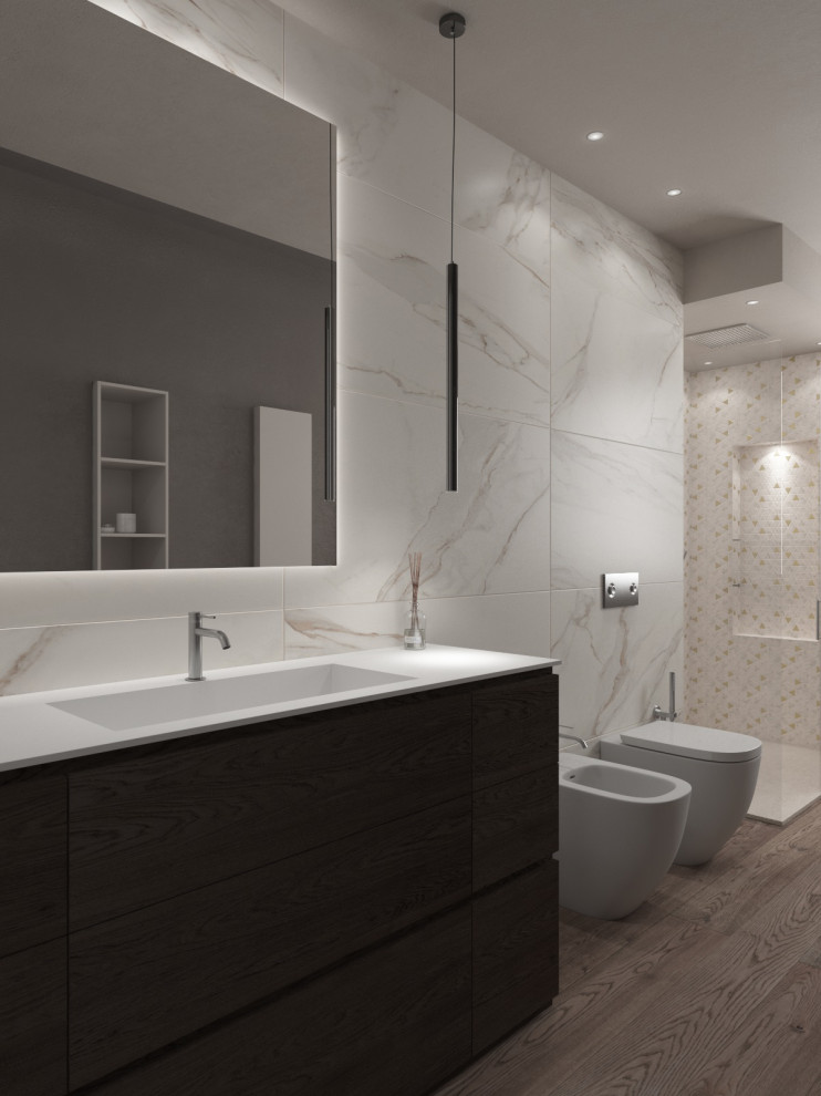 This is an example of a mid-sized modern 3/4 bathroom with flat-panel cabinets, medium wood cabinets, a two-piece toilet, white tile, porcelain tile, beige walls, porcelain floors, an integrated sink, solid surface benchtops, beige floor, white benchtops, a freestanding vanity, recessed, a corner shower, a hinged shower door and a single vanity.