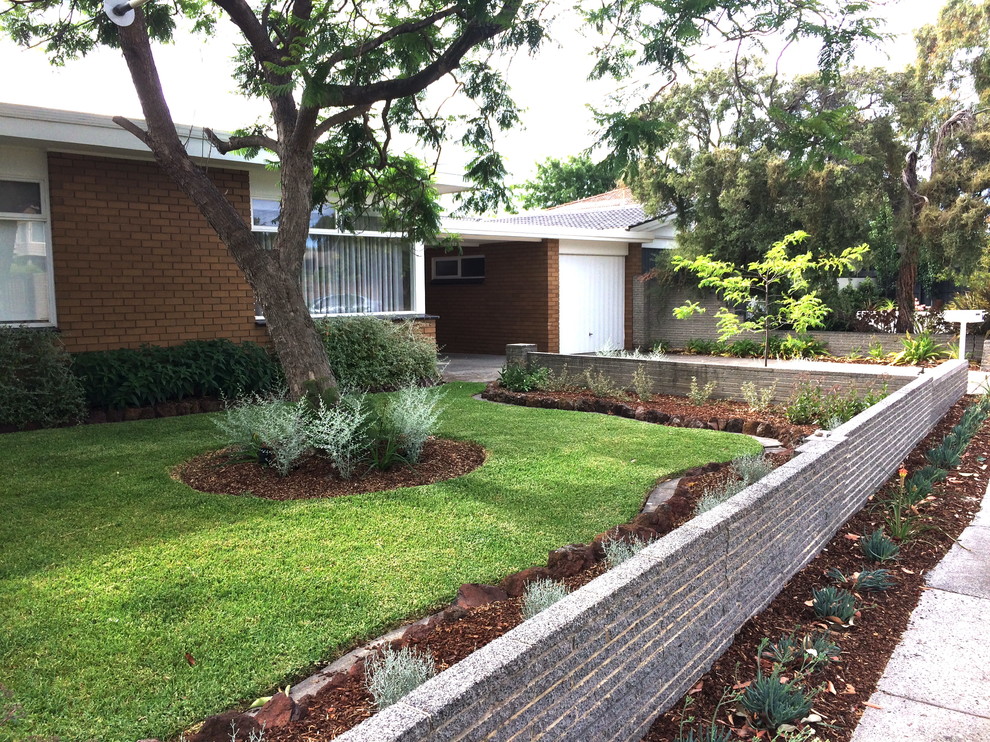 Small midcentury front yard full sun xeriscape in Melbourne with a garden path and concrete pavers.