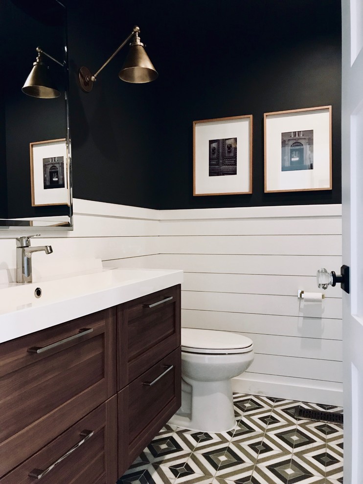 Photo of a small contemporary bathroom in Columbus with shaker cabinets, dark wood cabinets, a two-piece toilet, black walls, mosaic tile floors, an integrated sink, solid surface benchtops and white benchtops.