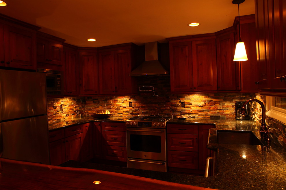 Inspiration for a small rustic u-shaped eat-in kitchen remodel with a single-bowl sink, raised-panel cabinets, medium tone wood cabinets, granite countertops, multicolored backsplash, stone slab backsplash, stainless steel appliances and no island